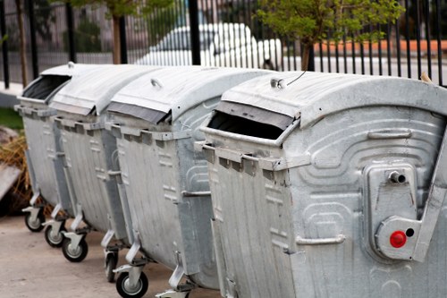 Workers beside commercial waste bins at a Sidcup business entrance, emphasizing accessibility access points